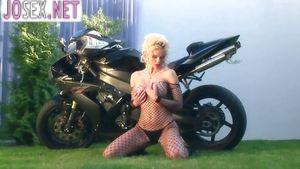 Busty blonde fondles herself on a motorcycle in nylon